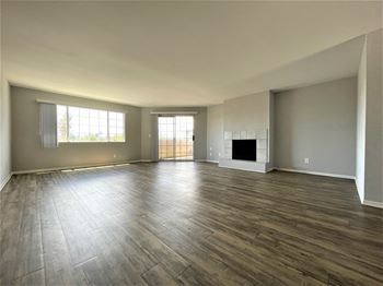 A spacious living room with wood flooring and a fireplace